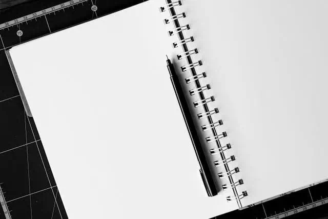 Black ballpoint pen on white notebook